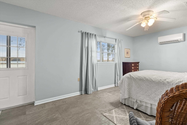 bedroom with ceiling fan, an AC wall unit, and a textured ceiling