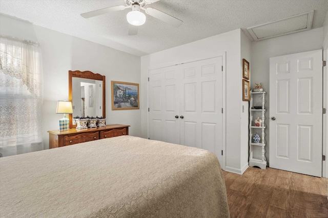 bedroom featuring hardwood / wood-style flooring, a closet, ceiling fan, and a textured ceiling