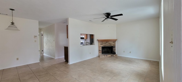 unfurnished living room featuring ceiling fan, light tile patterned floors, visible vents, baseboards, and a brick fireplace