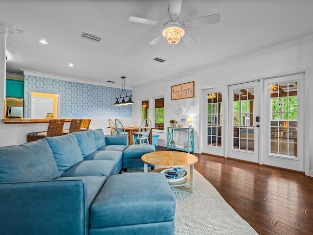 living room with french doors, crown molding, ceiling fan, and dark wood-type flooring