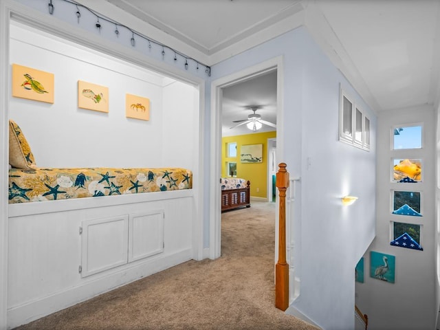 corridor featuring light colored carpet and crown molding