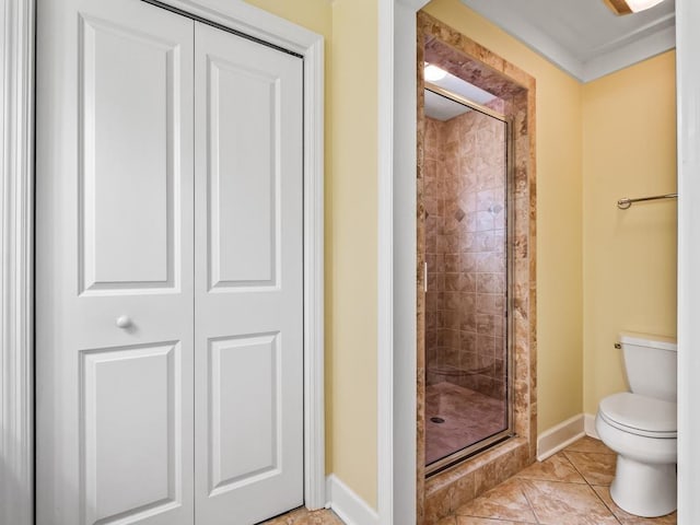 bathroom with tile patterned floors, toilet, and walk in shower