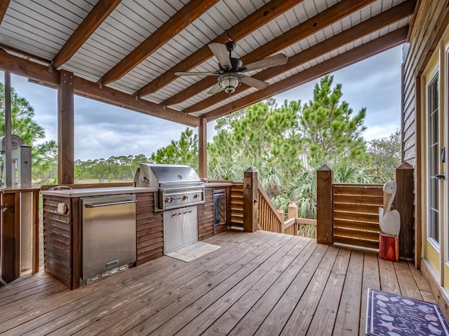 wooden deck featuring an outdoor kitchen, area for grilling, and ceiling fan