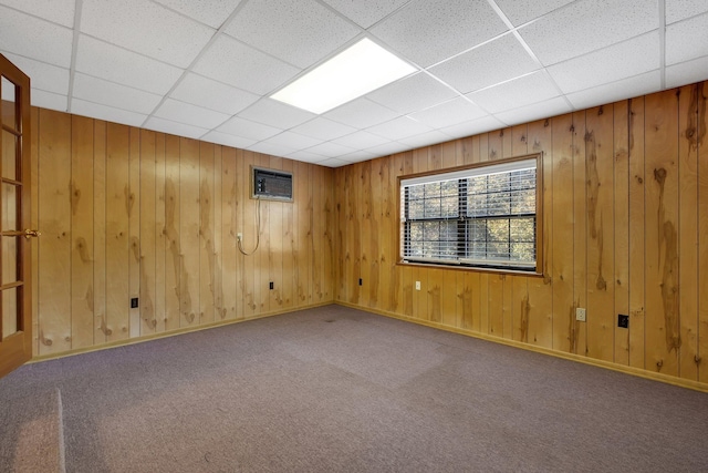 carpeted spare room featuring a paneled ceiling and a wall mounted AC