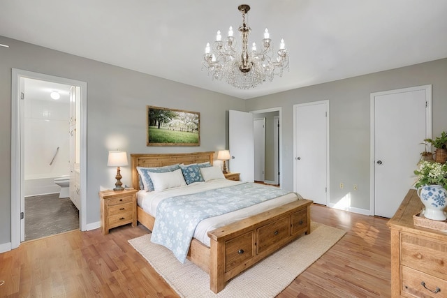 bedroom with a notable chandelier, light wood-type flooring, and ensuite bathroom