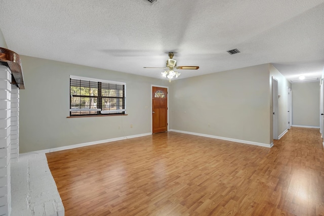 interior space with light wood-type flooring, ceiling fan, and a textured ceiling