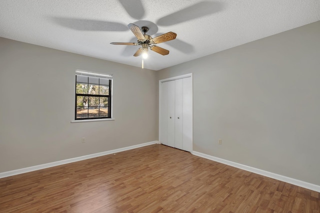 empty room featuring a textured ceiling, ceiling fan, and wood-type flooring