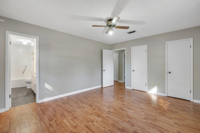 unfurnished bedroom featuring connected bathroom, ceiling fan, and light hardwood / wood-style flooring