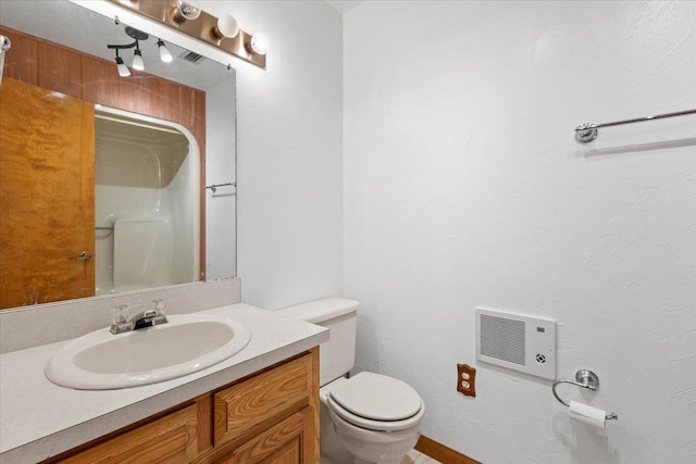 bathroom featuring vanity, toilet, a shower, and heating unit