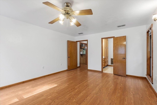 unfurnished bedroom with ensuite bathroom, light wood-type flooring, and ceiling fan