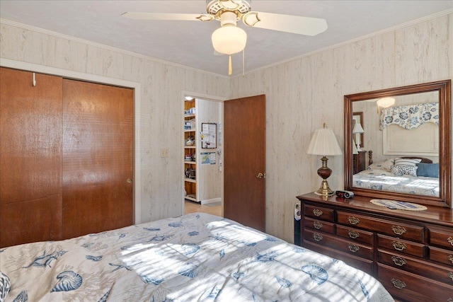 bedroom with a closet, ceiling fan, and crown molding