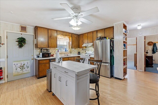 kitchen featuring stainless steel refrigerator, a center island, light hardwood / wood-style flooring, white range with electric cooktop, and white cabinets