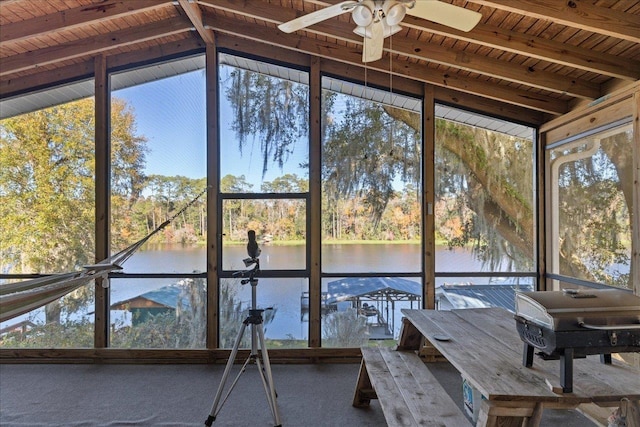 unfurnished sunroom with vaulted ceiling with beams, a water view, ceiling fan, and wooden ceiling