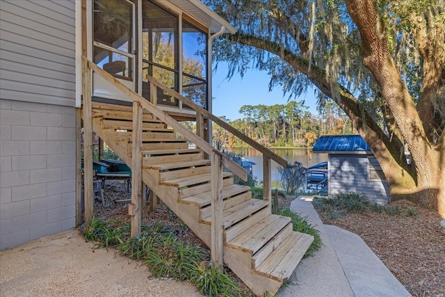 wooden terrace with an outbuilding and a water view