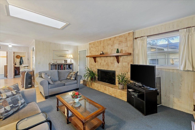 carpeted living room featuring a tiled fireplace