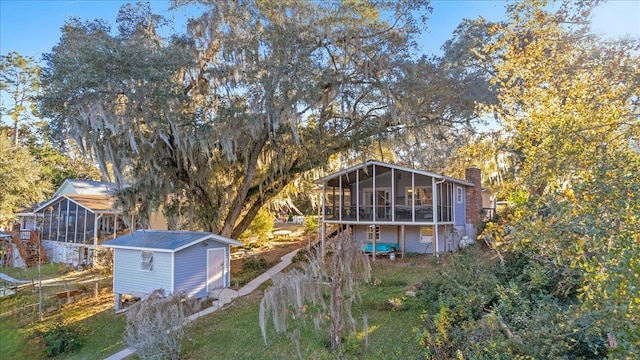 exterior space with a sunroom and a storage unit