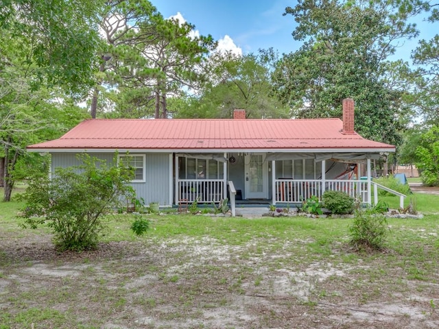 ranch-style home featuring covered porch and a front yard