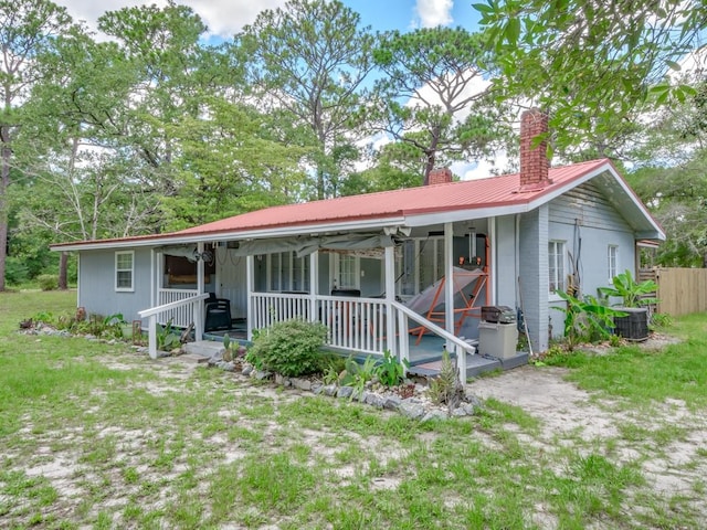 view of front of property with ceiling fan and a front yard