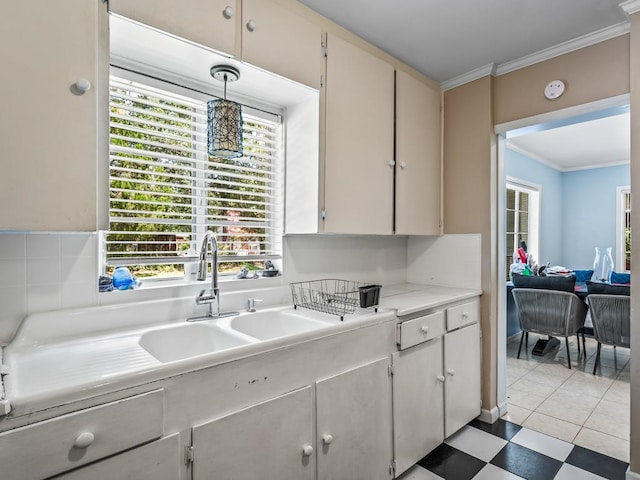 kitchen featuring pendant lighting, a wealth of natural light, crown molding, and sink