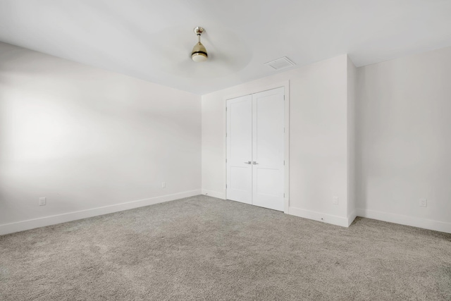 unfurnished bedroom with carpet flooring, ceiling fan, and a closet