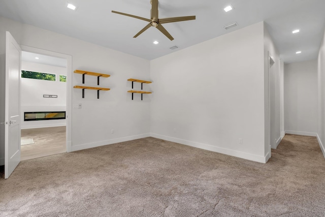 unfurnished room with light colored carpet and ceiling fan