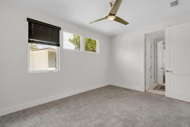 carpeted spare room with ceiling fan