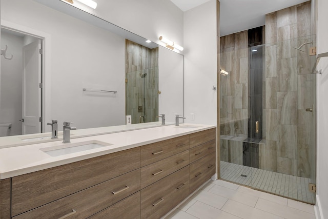 bathroom featuring tile patterned flooring, vanity, and a shower with shower door