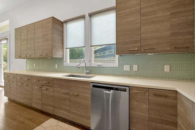 kitchen featuring decorative backsplash, stainless steel dishwasher, plenty of natural light, and sink