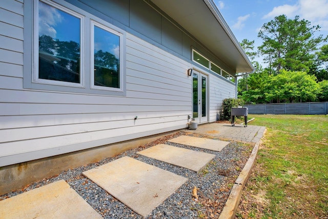 view of property exterior with a yard and a patio