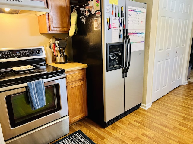 kitchen featuring light hardwood / wood-style floors, refrigerator with ice dispenser, and stainless steel electric range