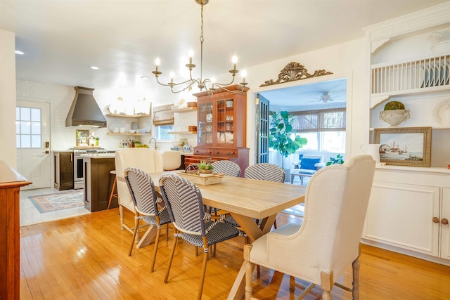 dining space with light hardwood / wood-style floors and a notable chandelier