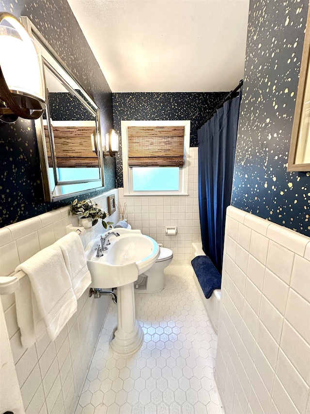 full bathroom featuring toilet, tile walls, tile patterned floors, and shower / bath combination with curtain