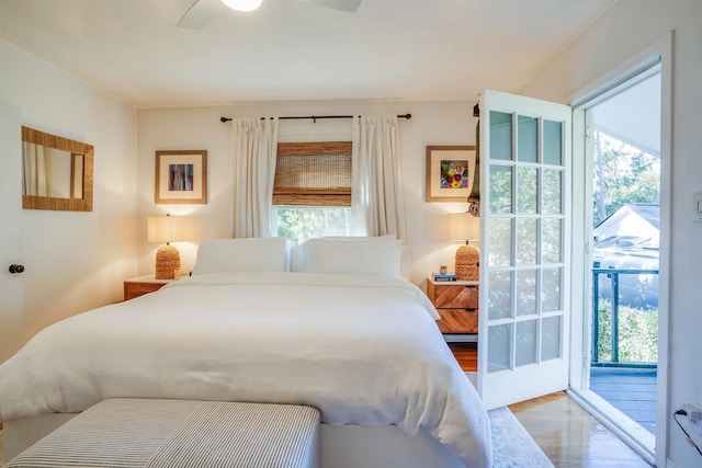 bedroom featuring access to outside, ceiling fan, multiple windows, and hardwood / wood-style floors