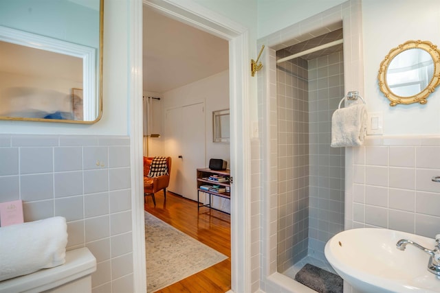 bathroom featuring tile walls, sink, tiled shower, and wood-type flooring