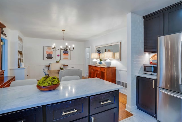 kitchen featuring decorative light fixtures, wine cooler, tasteful backsplash, a notable chandelier, and appliances with stainless steel finishes