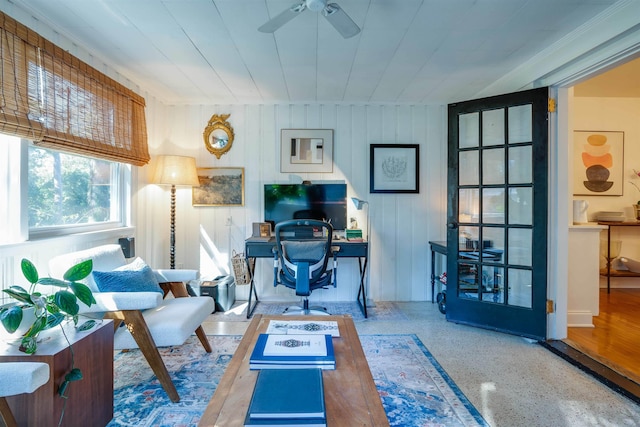 office featuring ceiling fan and wood walls