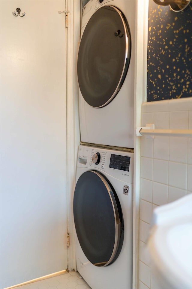 washroom featuring light tile patterned floors and stacked washer and clothes dryer