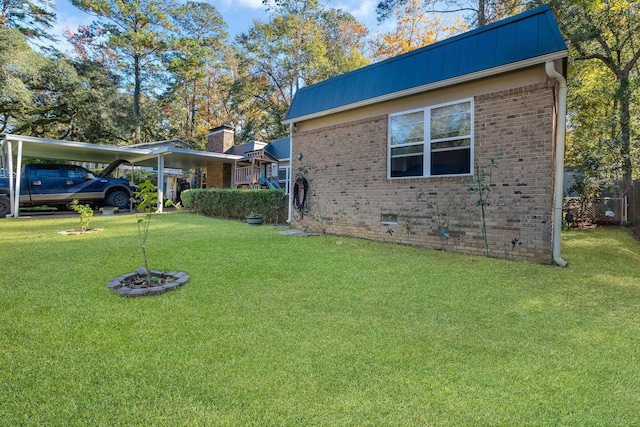 view of side of property with a carport and a lawn