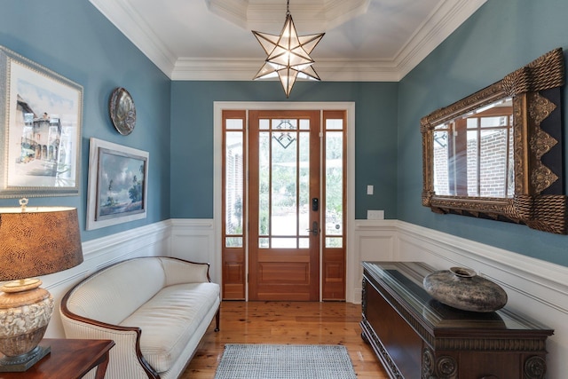 entrance foyer featuring plenty of natural light, crown molding, and light hardwood / wood-style flooring