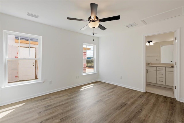 unfurnished bedroom with hardwood / wood-style flooring, ceiling fan, and ensuite bath