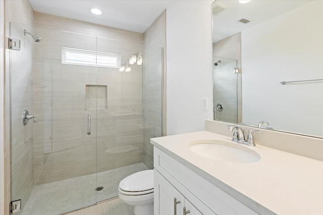 bathroom with vanity, tile patterned floors, toilet, and a shower with shower door