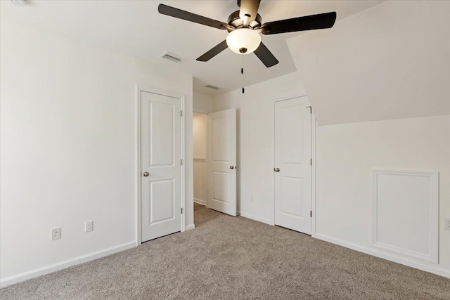 unfurnished bedroom featuring vaulted ceiling, light carpet, and ceiling fan