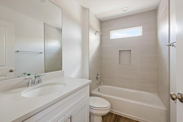 full bathroom featuring wood-type flooring, vanity, toilet, and tiled shower / bath combo