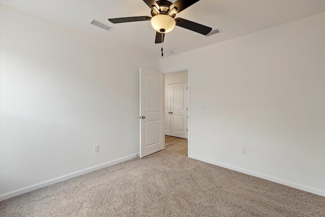 carpeted spare room featuring ceiling fan