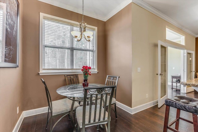 dining room with a chandelier, ornamental molding, and dark hardwood / wood-style floors