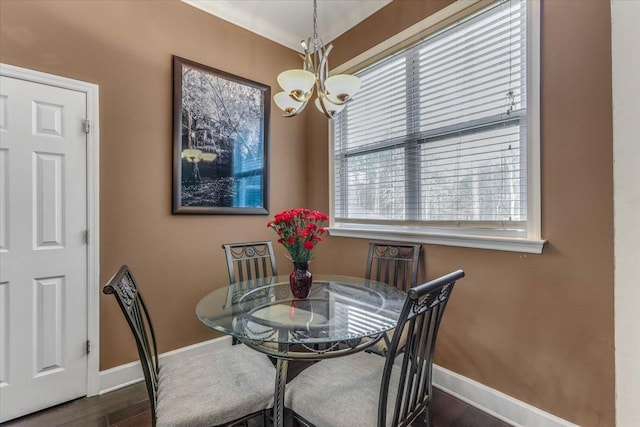 dining space featuring a chandelier, a healthy amount of sunlight, ornamental molding, and dark hardwood / wood-style floors