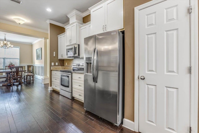 kitchen with white cabinets, stainless steel appliances, dark hardwood / wood-style floors, ornamental molding, and light stone counters