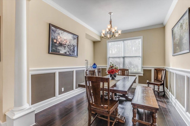 dining space featuring dark wood-type flooring, ornate columns, ornamental molding, and a notable chandelier