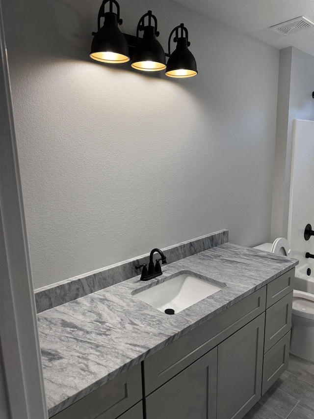 full bathroom featuring toilet, vanity, and bathtub / shower combination