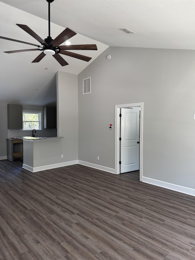 unfurnished living room featuring ceiling fan, sink, dark hardwood / wood-style flooring, and lofted ceiling